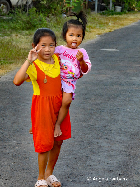 girl carrying little sister on road