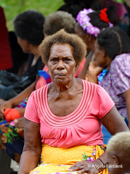 older woman in pink and yellow