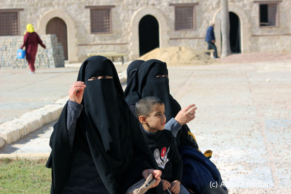 three women in black with young boy