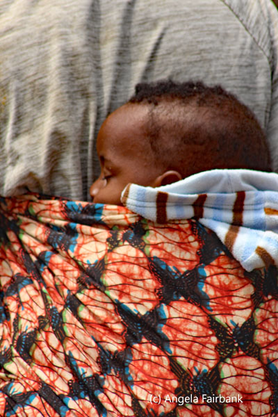 baby on back of woman