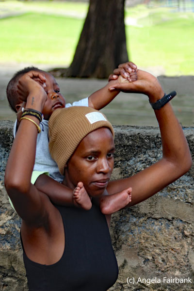 woman carrying baby on shoulders