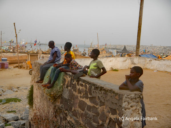 boys and man on wall outside slave castle