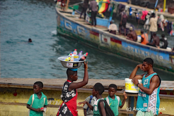 scene of people and boats near cape coast castle
