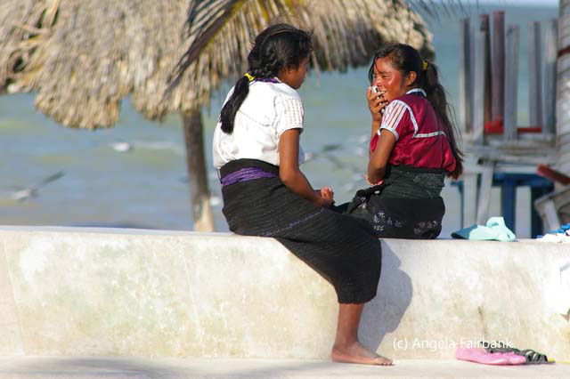 two girls sitting on wall