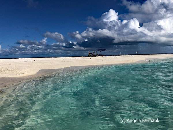 sliver of sand between sky and sea