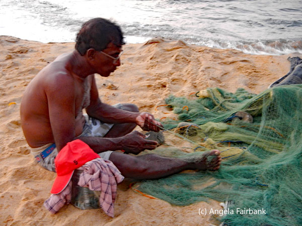 man in glasses repairing net